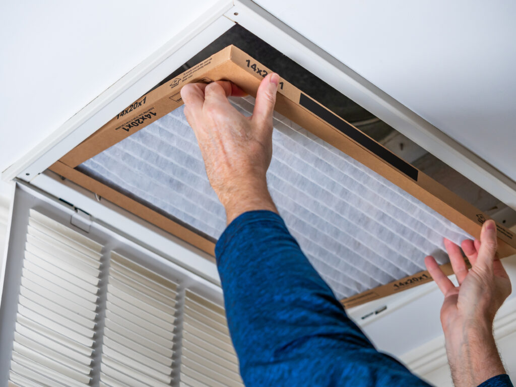 HVAC technician replacing a home air filter in Seal Beach