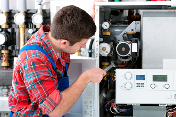 Heating technician repairing boiler controls in Seal Beach