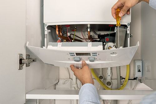 Heating technician repairing a residential boiler in Seal Beach
