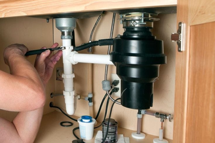 Plumber repairing a garbage disposal in Seal Beach