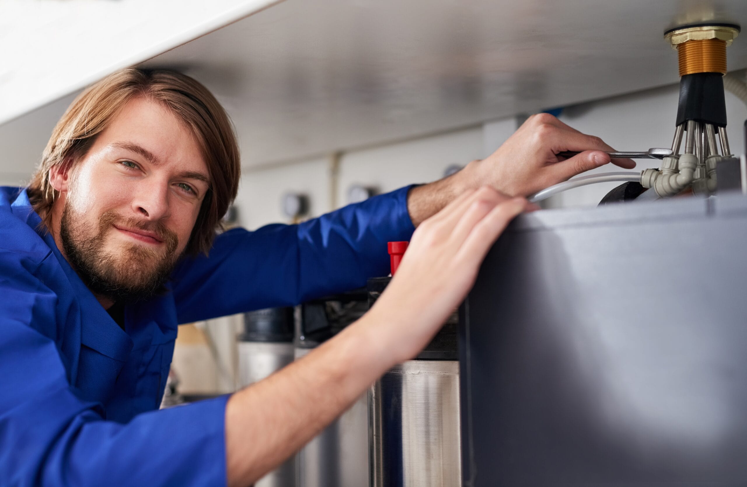 Technician servicing a residential water heater tank in Seal Beach